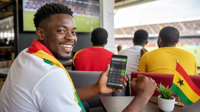 Ghana football supporters watching a match while checking a mobile betting screen